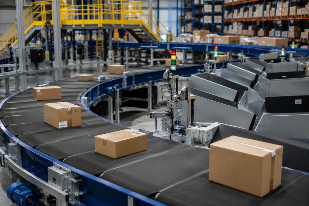 Automated conveyor and sorting system moving cardboard packages through a modern warehouse facility 

